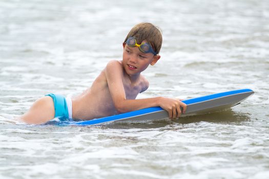 Young boy with a bodyboard on the beach