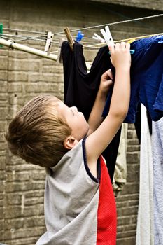 Child hanging laundry on a washing line.