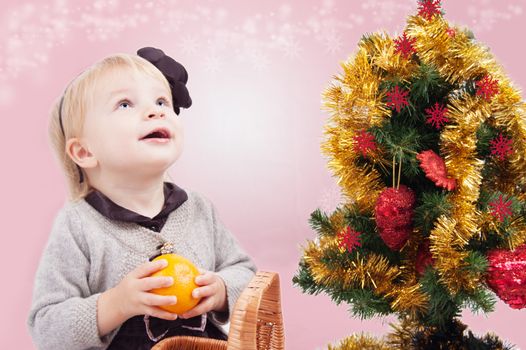 Surprised little girl looking up under Christmas tree