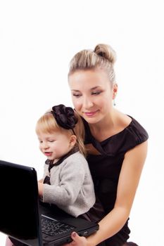Mother and little daughter at laptop on white