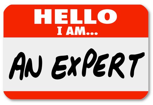 The words Hello I Am An Expert written on a red nametag or sticker for a consultant or other business professional to wear and solicit new clients and business for his firm or practice
