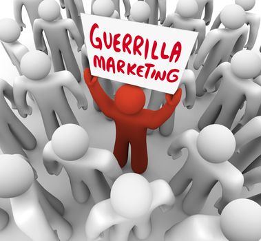 The words Guerrilla Marketing on a sign held by a unique person in a crowd, a marketer promoting his product or brand to customers in an audience