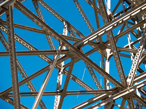 Steel framing, structural steel, criss-crossed and isloated against blue sky.