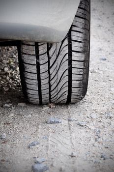 Close up of a car tire on a dirty road. Gritty look and vignetting on the corners of the image