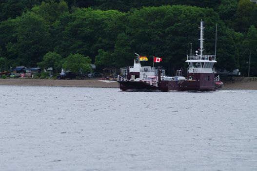 A river car ferry bring a load across the river