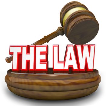 Words The Law on a wooden block with judge's gavel hovering over it, symbolizing, authority, jurisdiction, legislation, government or other authoritative power or rules to decide your fate