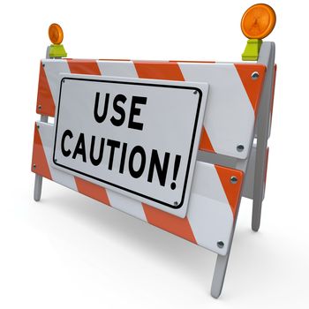 An orange and white construction barricade sign telling you to Use Caution when entering a dangerous area and warning you to be careful to avoid hazards