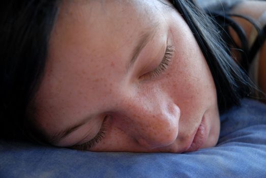 a young teenager sleeping in a blue bed