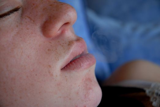 a young teenager making a smoke with her mouth