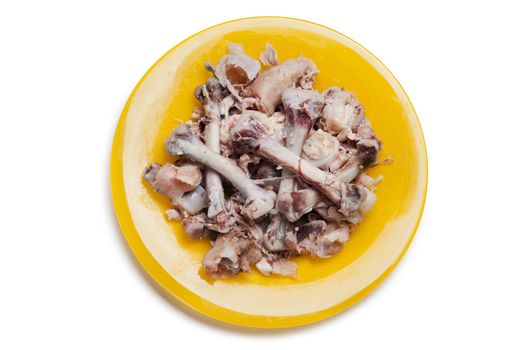 Food leftovers - chicken meat bones heap on plate white isolated