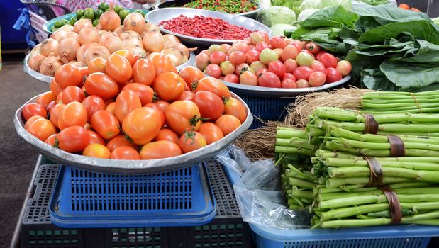 Baskets of tomatoes and vegetable for sale at a farmer's market. 