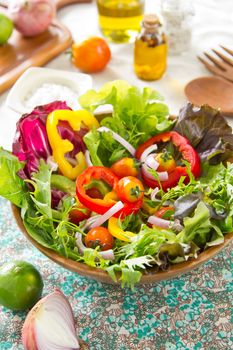 Fresh Vegetables salad in wood bowl by herbal salt and chilli oil