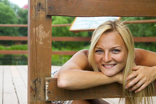 Young and beautiful woman on the pier by the forest lake