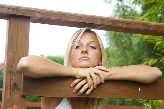 Young and beautiful woman on the pier by the forest lake