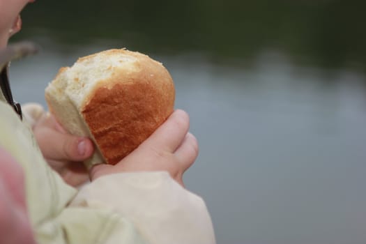 child taking a piece of bread at hands