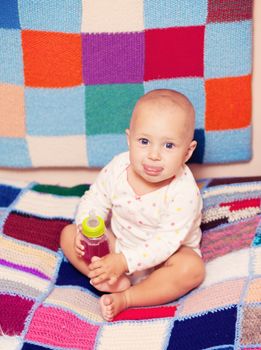 baby girl holding a bottle with juice