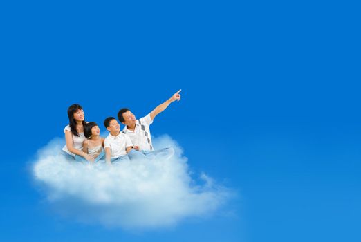 Happy Asian family sitting on cloud and pointing over blue sky