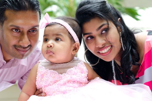 Indian parents and baby girl at outdoor home garden