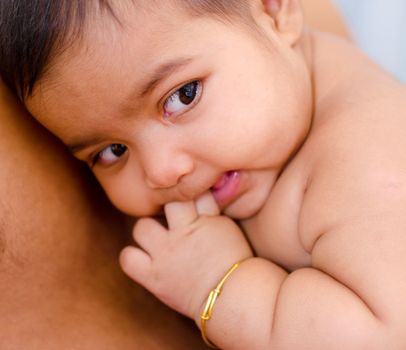 Six months old Indian baby girl is lying on daddy chest