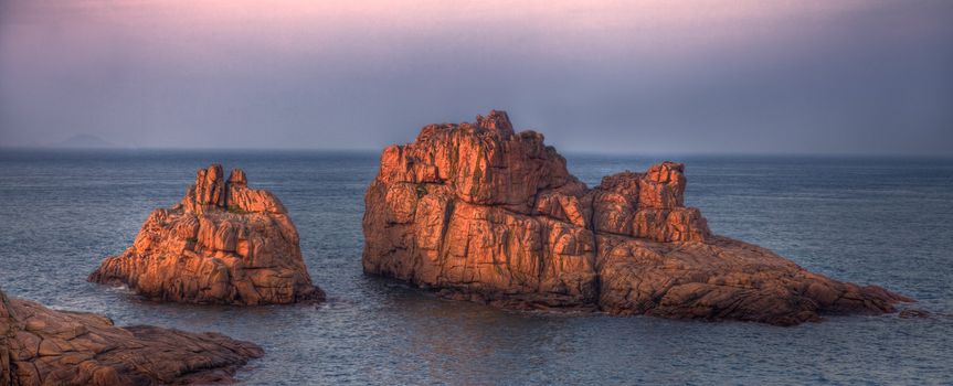 Beautiful image at the sunset of rocks and sea located in Pink Granite Coast in Brittany in northwest of France.