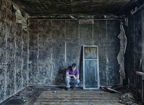  sad man, sitting  in burnt  room