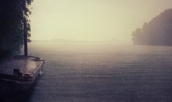 rain on the lake and old boat photo