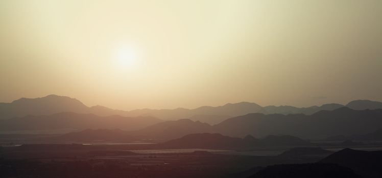 the silhouette of the mountains at sunset