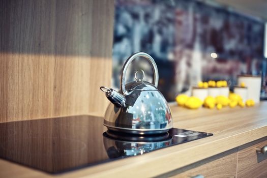 Shiny tea kettle on the kitchen table (beautiful diepth of field effect)