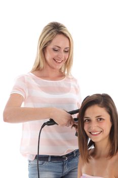 Young attractive smiling hairstylist standing styling a woman's hair isolated on white 