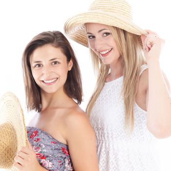 Happy female friends enjoying the summer in their casual sleeveless dresses and straw sunhats Happy female friends enjoying the summer in their casual sleevelss dresses and straw sunhats