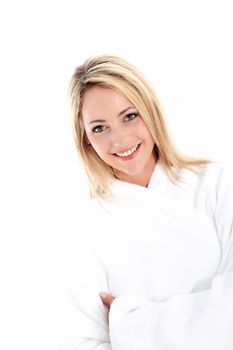 Happy healthy woman with a lovely radiant smile standing in a white bathrobe denoting purity and freshness 