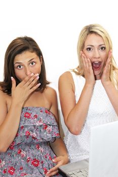 Two women reacting in unison with expressions of shocked awe as they raise their hands to their faces isolated on white 
