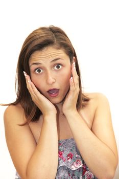 Woman reacting in amazement and surprise with wide eyes, her mouth open and her hands to her face 