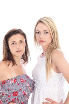 Two serious displeased women standing close together with their heads turned to the camera isolated on white Two serious displeased women standing close together with their heads turned to the camera isolated on white