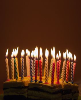 Background of lighted candles on top of birthday cake