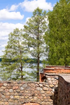 A wall and green trees of Trakaj castle in Lithuania
