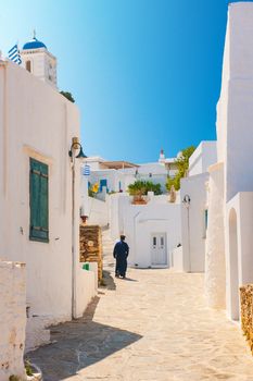 Greek Orthodox priest walking in an alleyway on the island of Sifnos