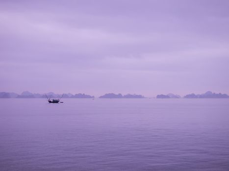 Boat sailing along the coast of Halong Bay, Vietnam. 