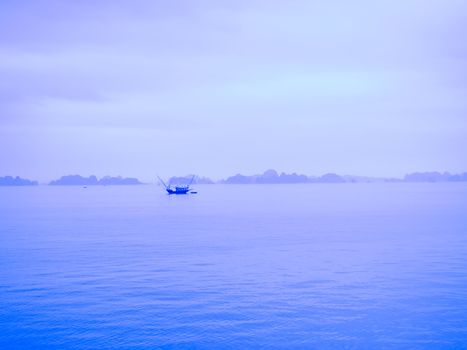 A boat sailing along the coast of Halong Bay, Vietnam. 