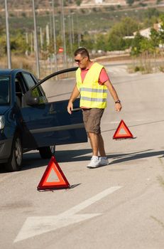 Guy having just broken down on a lonely road