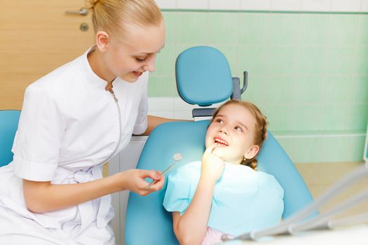 Little girl sitting in the dentists office