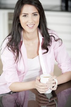 Young woman drinking a cup of coffee at home