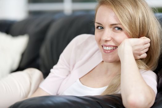 Young woman lying on sofa at home