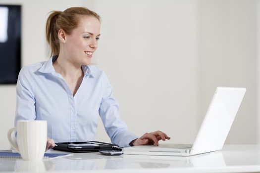 Young woman working at her desk in the office