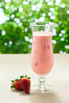 Strawberry milkshake in front of a green background