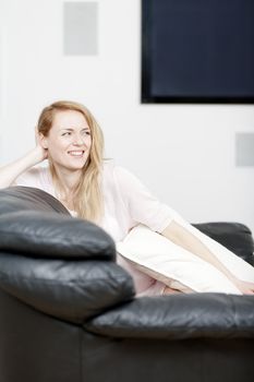 Young woman lying on sofa at home