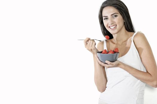 Beautiful young woman enjoying fresh fruit for breakfast at home