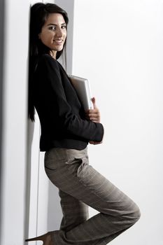 Professional working woman in corporate business suit holding a laptop computer