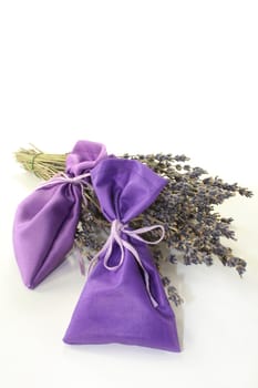 dried lavender flowers and lavender bags against white background