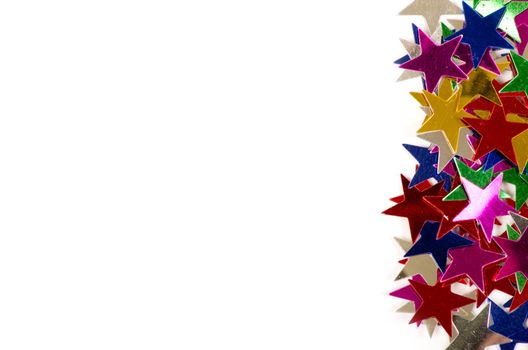 Christmas decoration of colored confetti stars against white background